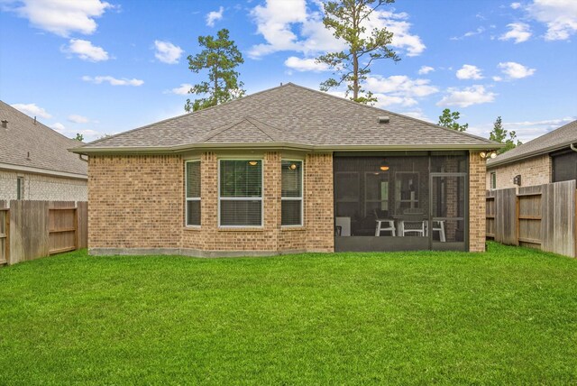 back of property with a lawn and a sunroom