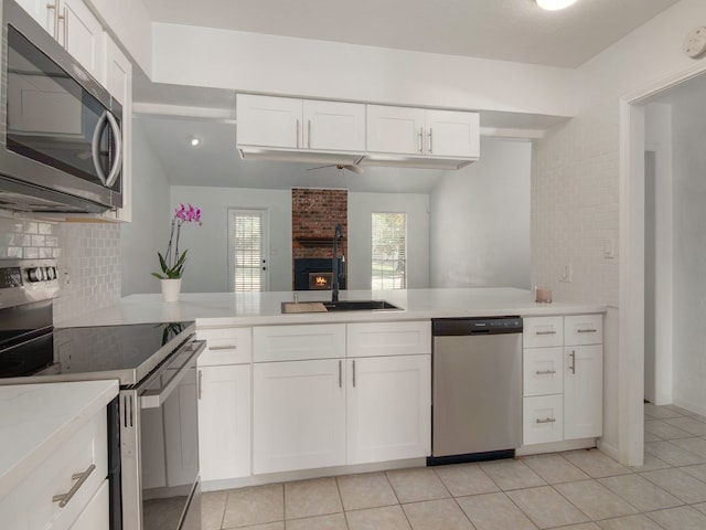 kitchen featuring kitchen peninsula, appliances with stainless steel finishes, and white cabinetry