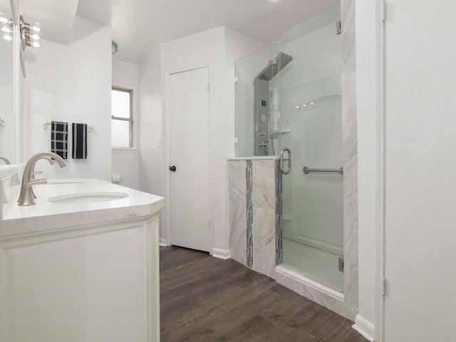 bathroom featuring hardwood / wood-style floors, vanity, and a shower with shower door