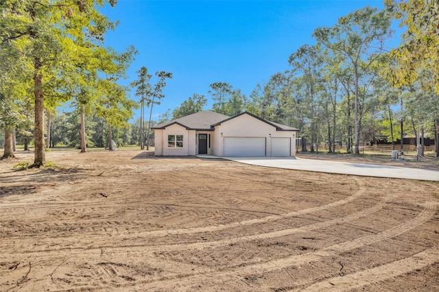 single story home featuring driveway, a garage, and stucco siding