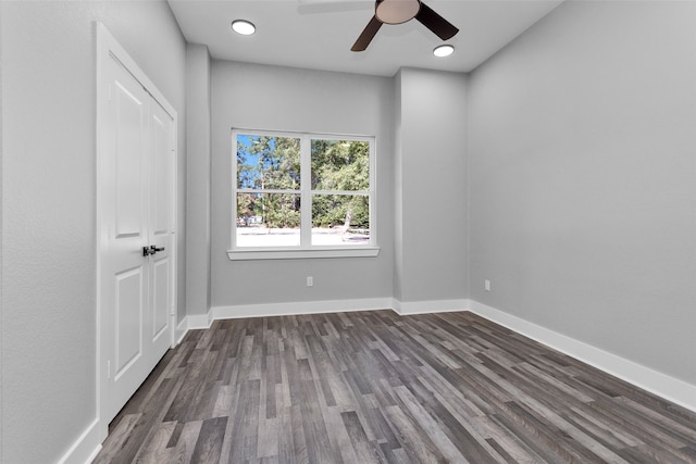 unfurnished room featuring dark wood-type flooring and ceiling fan