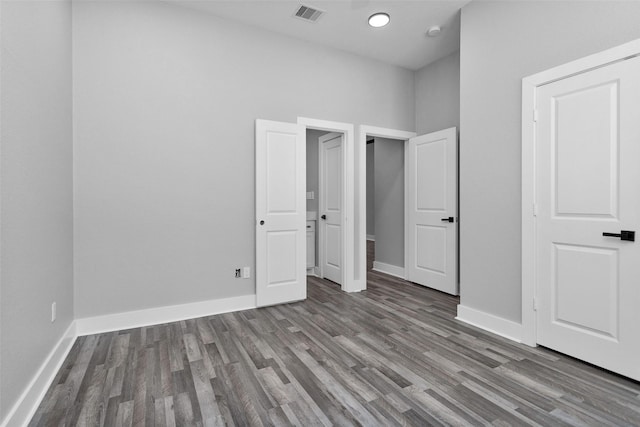 unfurnished bedroom featuring visible vents, baseboards, and wood finished floors