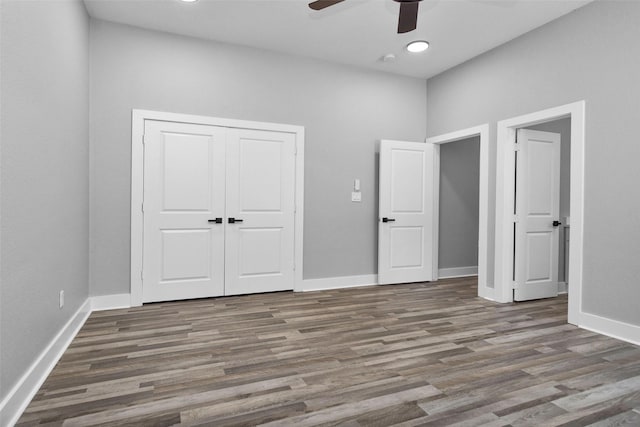 unfurnished bedroom with a ceiling fan, a closet, baseboards, and wood finished floors