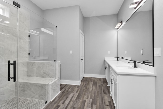 full bathroom with baseboards, wood finished floors, a sink, and a shower stall