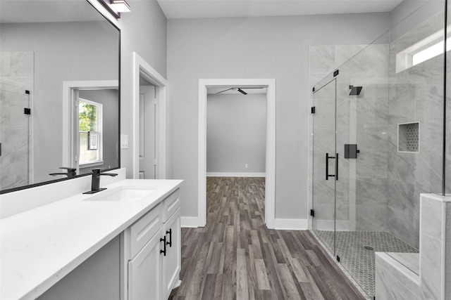 full bath featuring a shower stall, baseboards, wood finished floors, and vanity