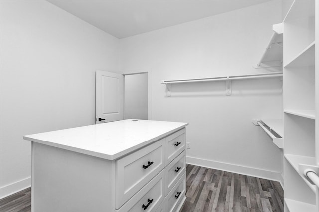 walk in closet with dark wood-type flooring