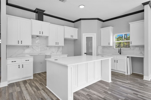 kitchen featuring light hardwood / wood-style floors, a center island, white cabinets, and decorative backsplash