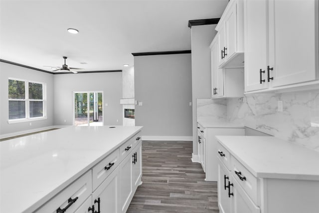 kitchen with backsplash, crown molding, hardwood / wood-style flooring, ceiling fan, and white cabinets