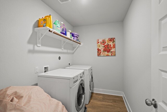 washroom with dark wood-type flooring and separate washer and dryer