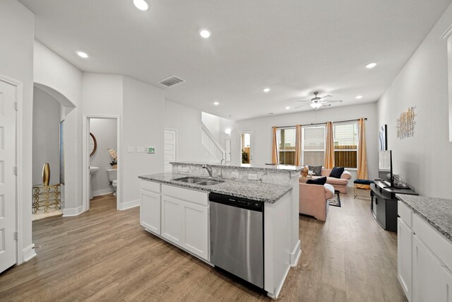 kitchen with light wood-type flooring, white cabinetry, light stone countertops, ceiling fan, and stainless steel dishwasher