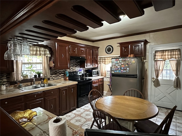 kitchen featuring plenty of natural light, stainless steel appliances, light tile patterned floors, and tasteful backsplash