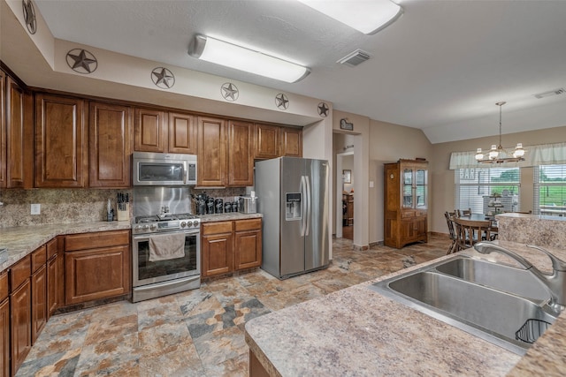 kitchen with sink, a notable chandelier, appliances with stainless steel finishes, and tasteful backsplash