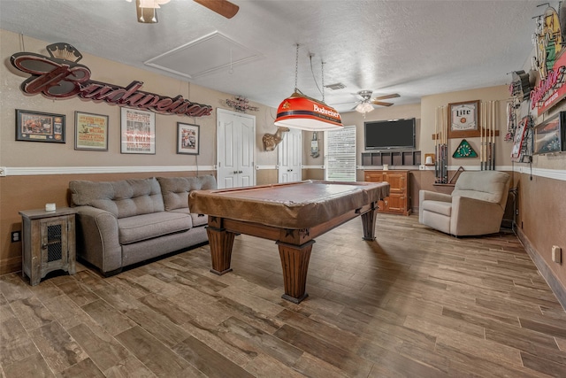 game room with a textured ceiling, ceiling fan, pool table, and hardwood / wood-style flooring