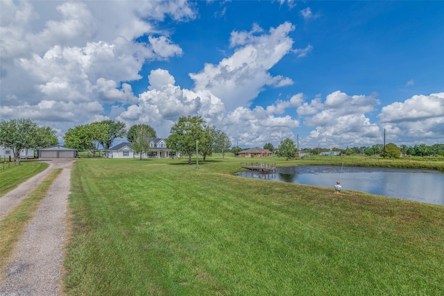 view of yard featuring a water view and a garage