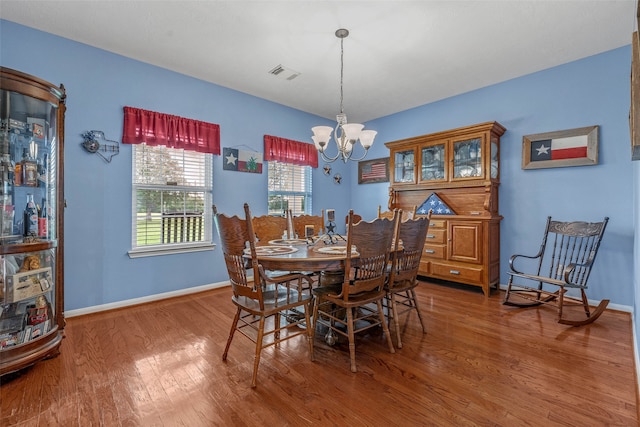 dining room featuring hardwood / wood-style flooring and an inviting chandelier