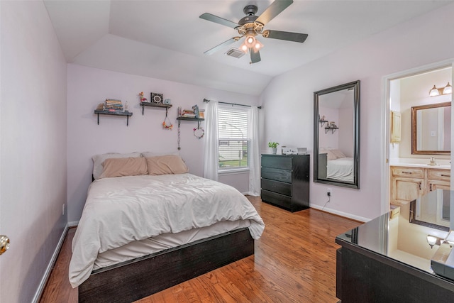 bedroom featuring ensuite bath, lofted ceiling, hardwood / wood-style flooring, and ceiling fan