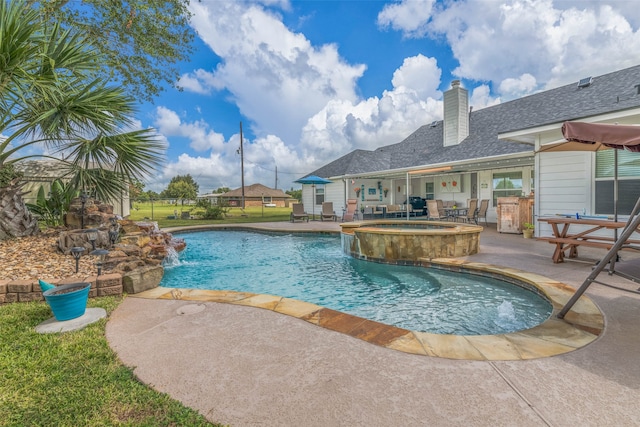 view of pool featuring an in ground hot tub, pool water feature, and a patio