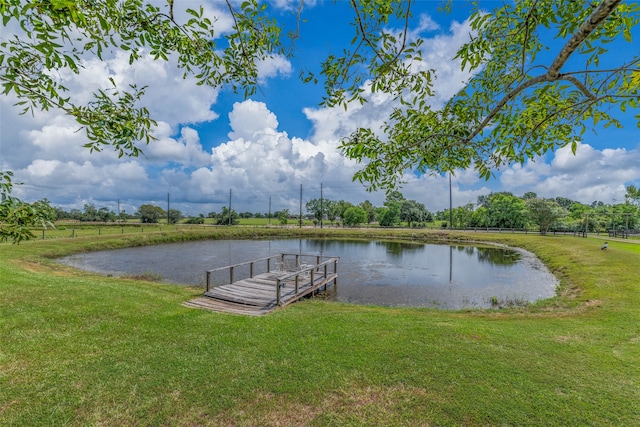 dock area with a lawn and a water view