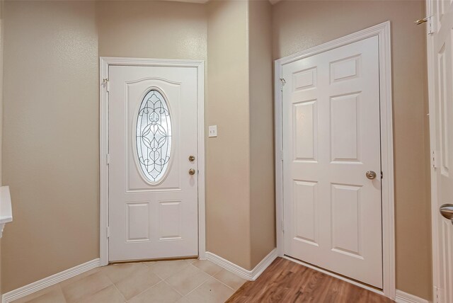 entryway with light wood-style flooring and baseboards