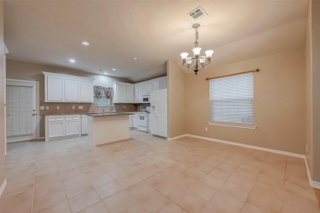 kitchen with a notable chandelier, tasteful backsplash, visible vents, white cabinetry, and white appliances