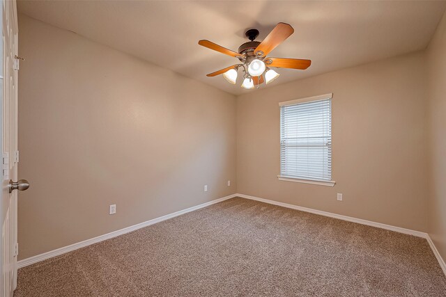 spare room with carpet, ceiling fan, and baseboards