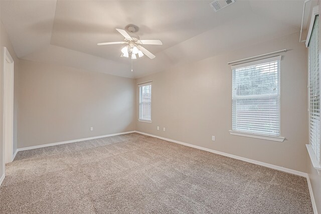 empty room with baseboards, visible vents, a ceiling fan, and light colored carpet