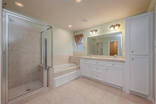 bathroom with visible vents, a stall shower, a sink, and a bath