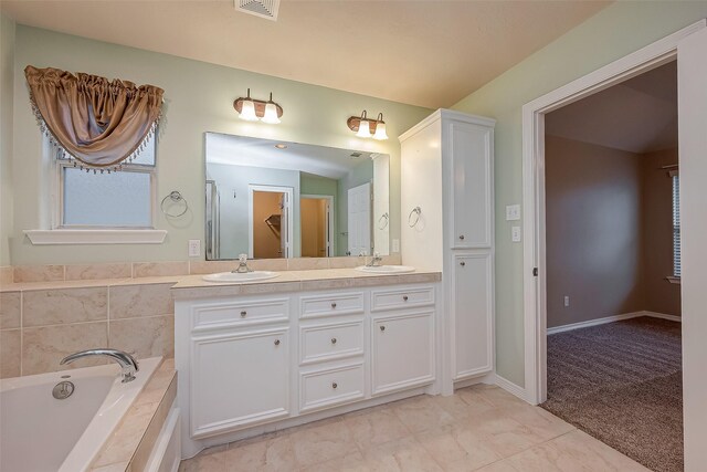 full bathroom featuring a closet, double vanity, a sink, and a bath