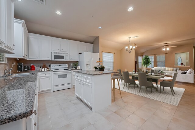 kitchen featuring white appliances, a sink, white cabinets, vaulted ceiling, and open floor plan