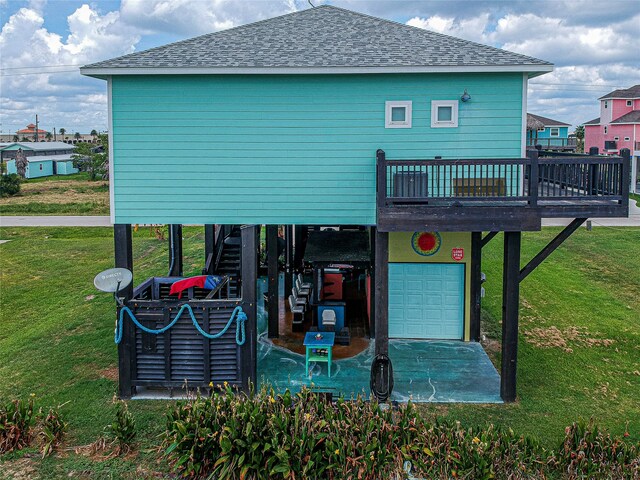 rear view of house with a yard, a garage, and a wooden deck