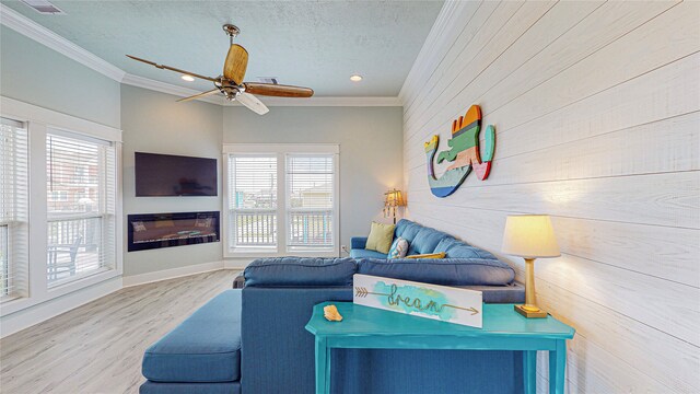 living room with ceiling fan, a textured ceiling, crown molding, and hardwood / wood-style floors