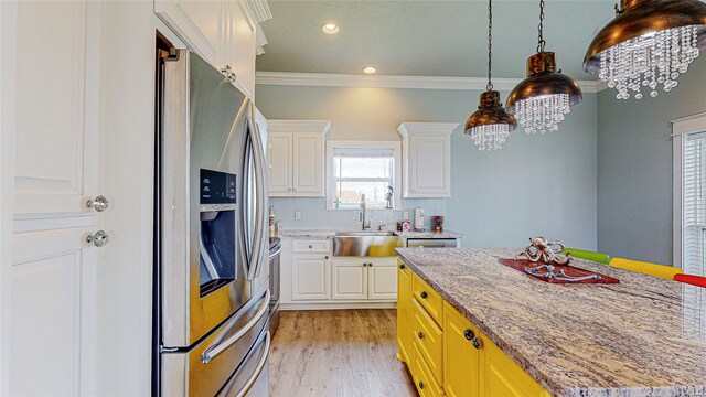 kitchen with white cabinets, sink, stainless steel fridge with ice dispenser, light wood-type flooring, and decorative backsplash