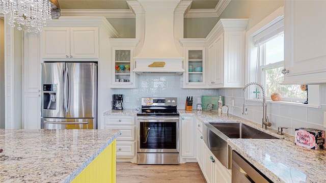 kitchen with light stone counters, white cabinets, custom exhaust hood, light hardwood / wood-style flooring, and stainless steel appliances