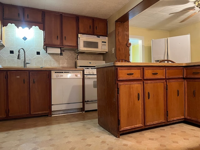 kitchen with ceiling fan, sink, white appliances, and tasteful backsplash