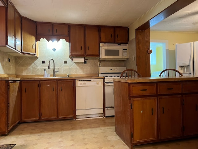 kitchen featuring white appliances, tasteful backsplash, and sink