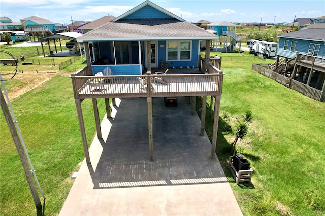 rear view of house featuring a lawn and a carport