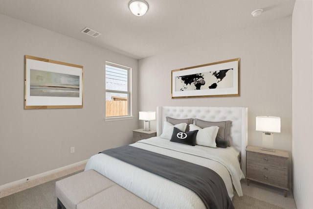 carpeted bedroom with visible vents and baseboards