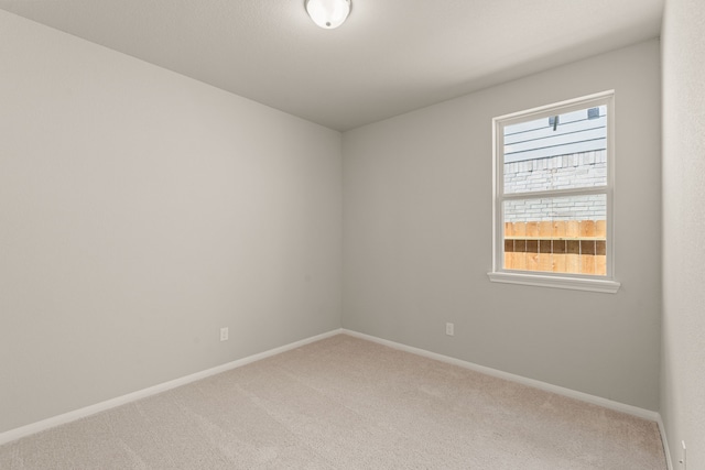 carpeted empty room with baseboards