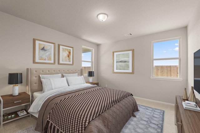 bedroom featuring multiple windows, carpet flooring, visible vents, and baseboards