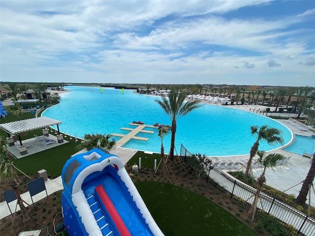 pool with a water view and fence