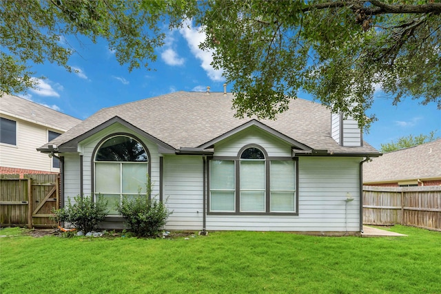 rear view of property with a yard