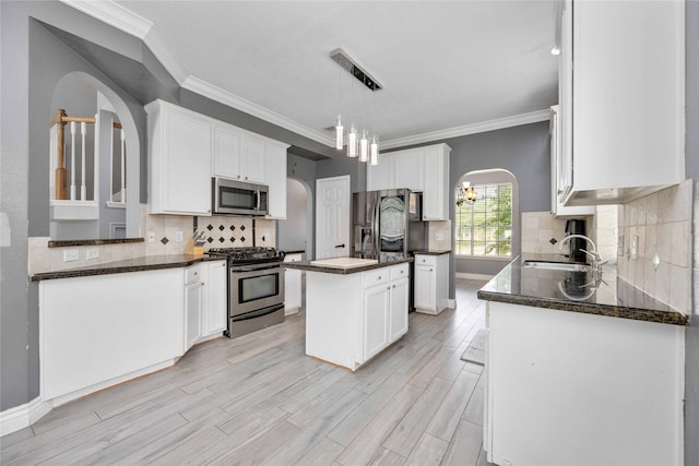 kitchen with light hardwood / wood-style flooring, stainless steel appliances, a center island, sink, and white cabinets