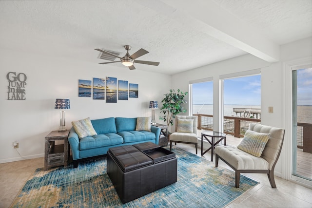 living room with a textured ceiling, a water view, ceiling fan, and beamed ceiling