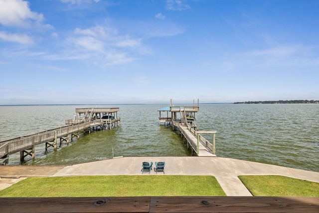 dock area with a lawn and a water view