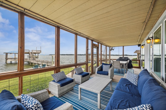 sunroom / solarium featuring a water view and wooden ceiling