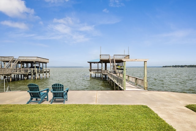 view of dock with a water view and a lawn