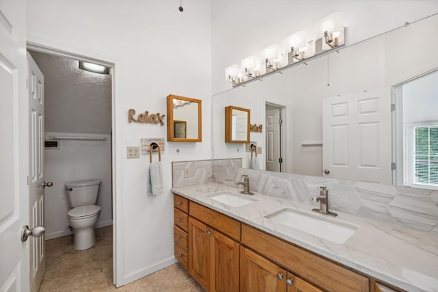 bathroom with vanity, toilet, tile patterned floors, and a textured ceiling