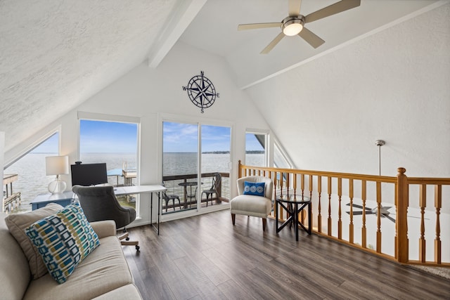 living room featuring ceiling fan, dark hardwood / wood-style floors, vaulted ceiling with beams, and a water view