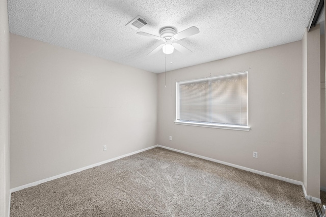 unfurnished room with carpet, ceiling fan, and a textured ceiling