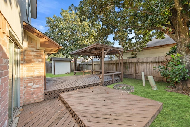 wooden terrace with a storage shed, a gazebo, and a yard